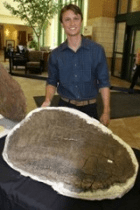 스테고사우루스의 골판 옆에 서있는 에반 사이타. Photograph: Billings Clinic, Montana